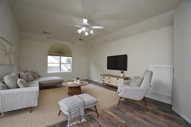 living room featuring ceiling fan and dark wood-type flooring