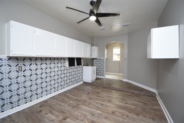 empty room with hardwood / wood-style floors, ceiling fan, and sink