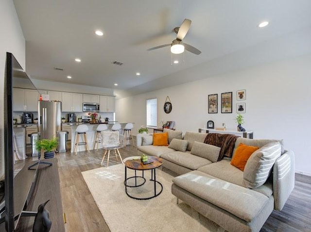 living room with ceiling fan and light wood-type flooring