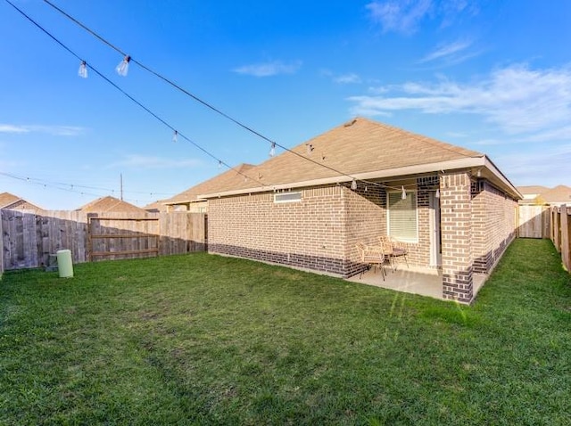 back of house with a patio area and a lawn