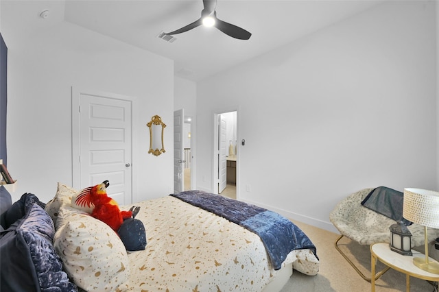 carpeted bedroom with ensuite bath and ceiling fan