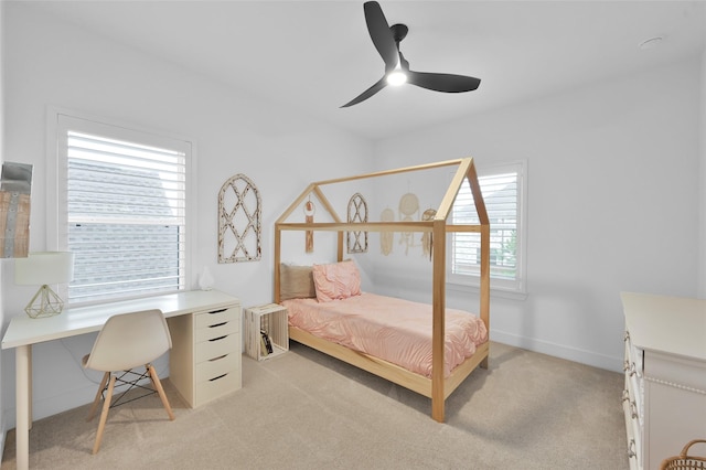 bedroom with multiple windows, ceiling fan, and light carpet