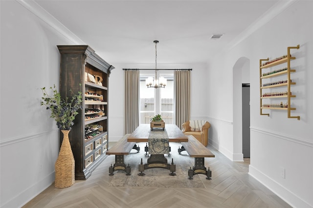 dining space featuring light parquet floors, a notable chandelier, and ornamental molding