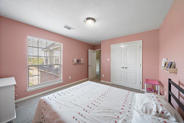 bedroom featuring a closet, carpet, and a textured ceiling