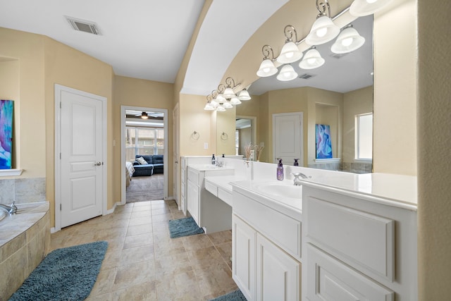 bathroom featuring tile patterned floors, vanity, ceiling fan, and tiled tub