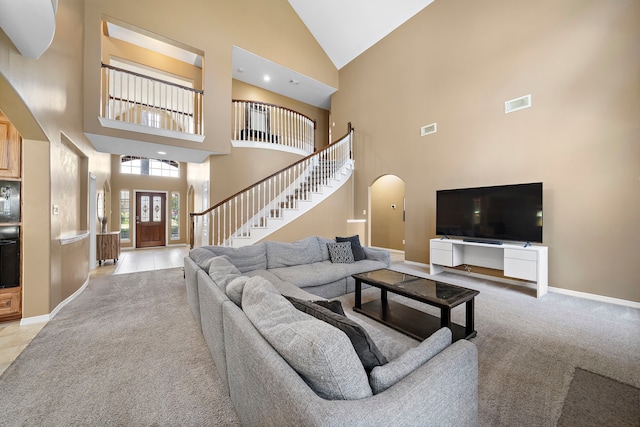 carpeted living room featuring high vaulted ceiling