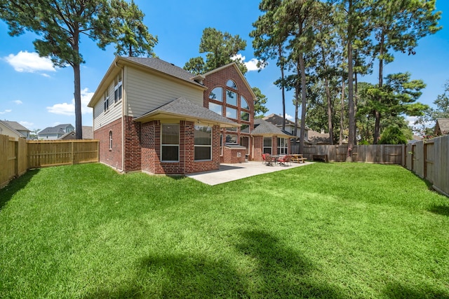 rear view of property featuring a yard and a patio