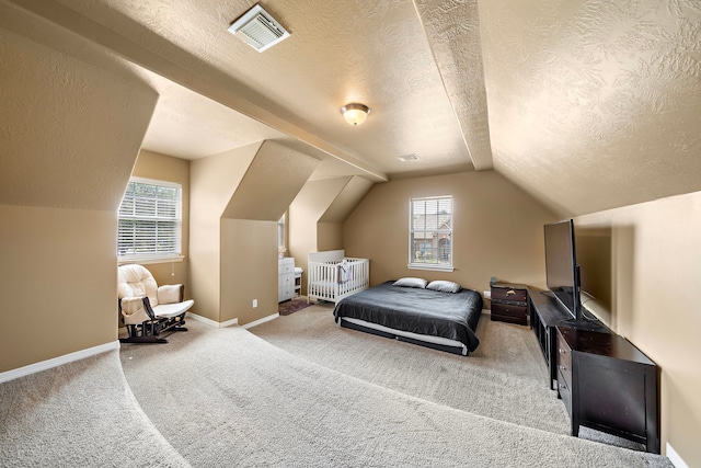 carpeted bedroom with lofted ceiling and a textured ceiling