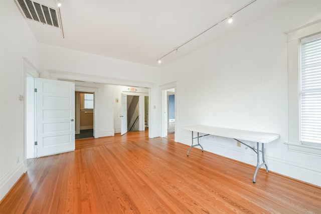 empty room featuring rail lighting and light wood-type flooring