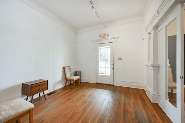 doorway featuring hardwood / wood-style flooring, track lighting, and crown molding