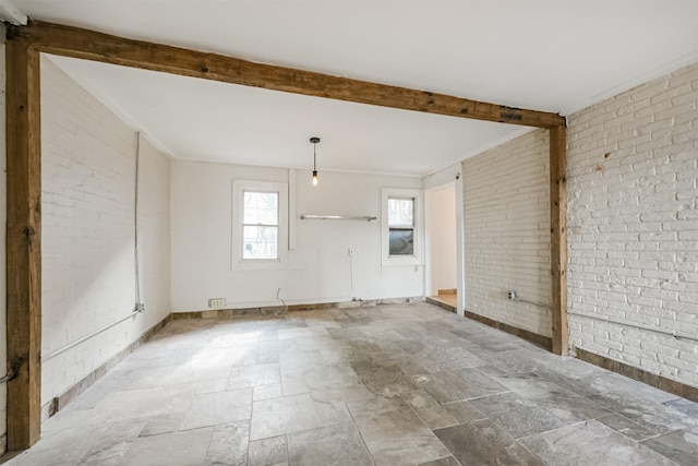 unfurnished room featuring brick wall