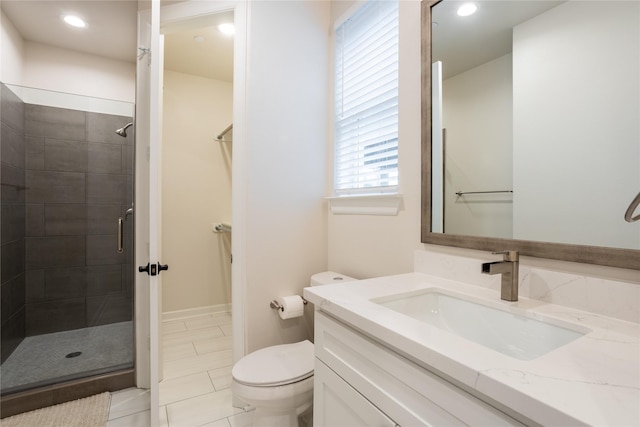 bathroom with a shower with door, vanity, and toilet