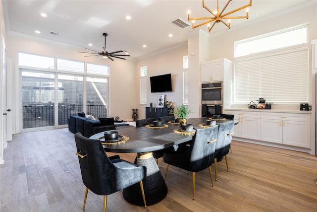 dining area with ceiling fan with notable chandelier, crown molding, and light hardwood / wood-style flooring