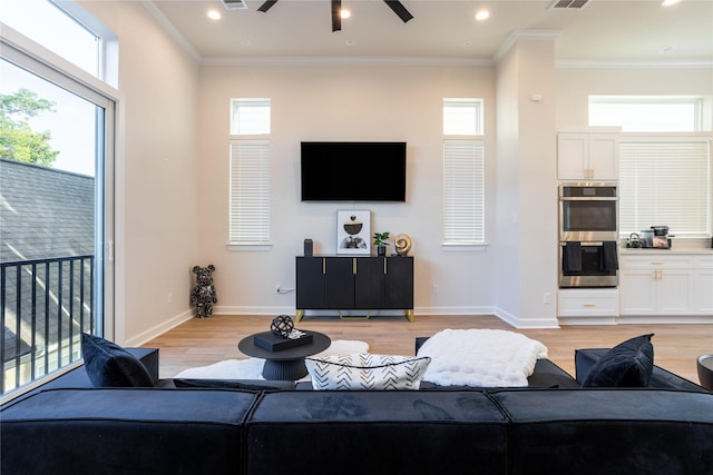 living room featuring light hardwood / wood-style floors, plenty of natural light, and ornamental molding