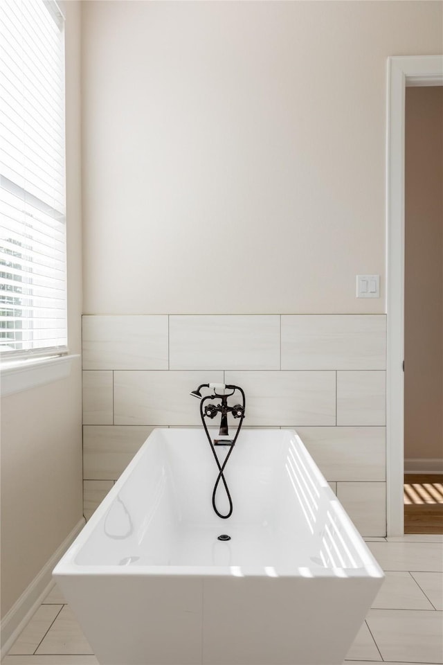 bathroom with tile patterned floors and a tub