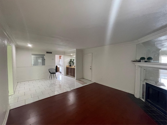 unfurnished living room with a tiled fireplace, ornamental molding, a textured ceiling, and light hardwood / wood-style flooring