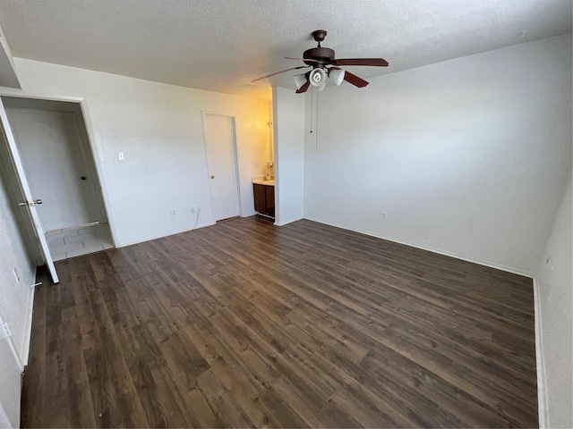 spare room featuring a textured ceiling, ceiling fan, and dark wood-type flooring