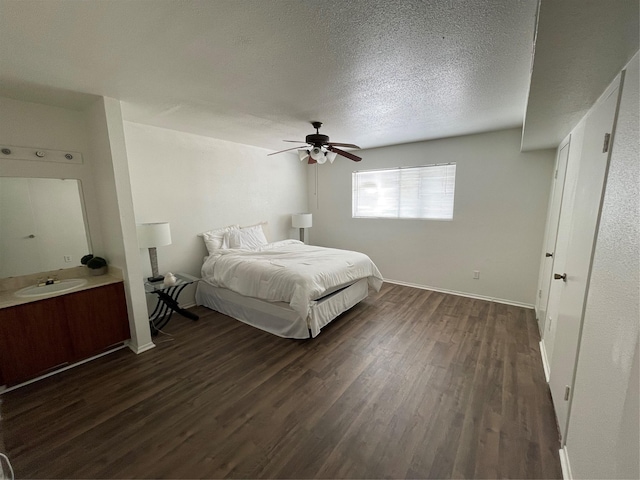 unfurnished bedroom featuring a textured ceiling, ceiling fan, dark wood-type flooring, and sink