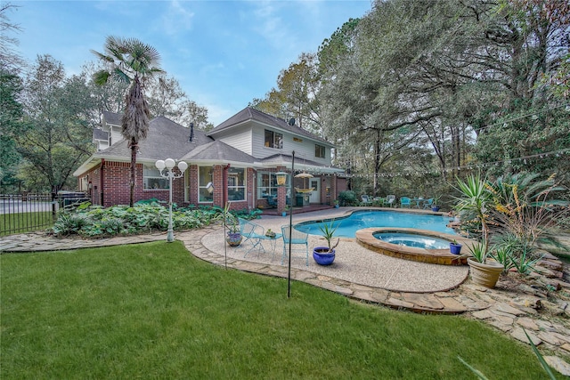 view of swimming pool featuring an in ground hot tub, a yard, and a patio