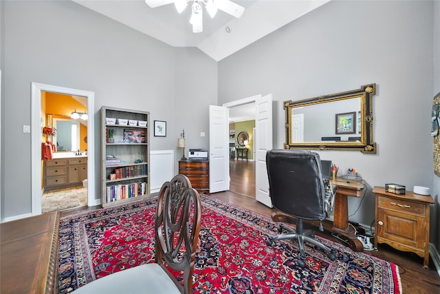 home office with dark hardwood / wood-style flooring, high vaulted ceiling, and ceiling fan