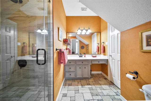 bathroom with a shower with door, vanity, and a textured ceiling