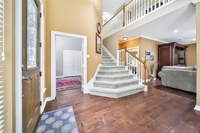 entryway featuring a high ceiling, dark hardwood / wood-style flooring, and ornamental molding