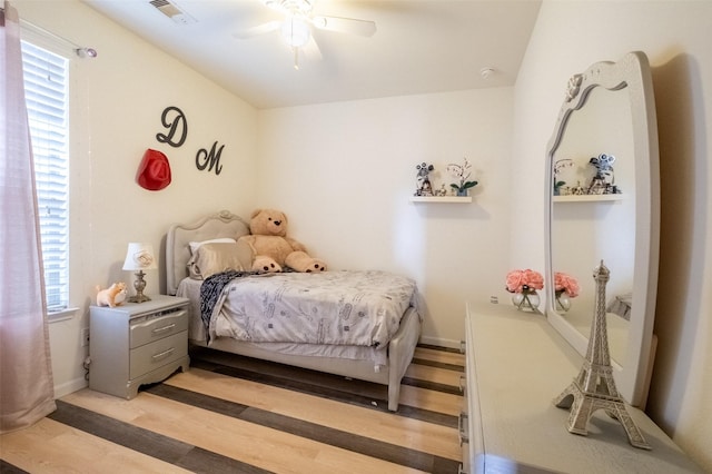 bedroom featuring multiple windows, ceiling fan, and light wood-type flooring