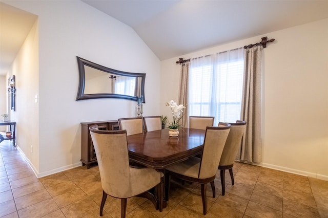 dining space with tile patterned flooring and vaulted ceiling