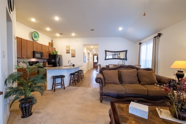 living room featuring lofted ceiling, sink, and light carpet