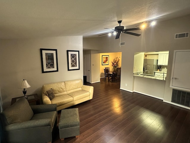 living room with dark hardwood / wood-style floors, ceiling fan, a textured ceiling, and high vaulted ceiling