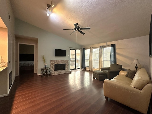 living room with a textured ceiling, dark hardwood / wood-style flooring, ceiling fan, and lofted ceiling