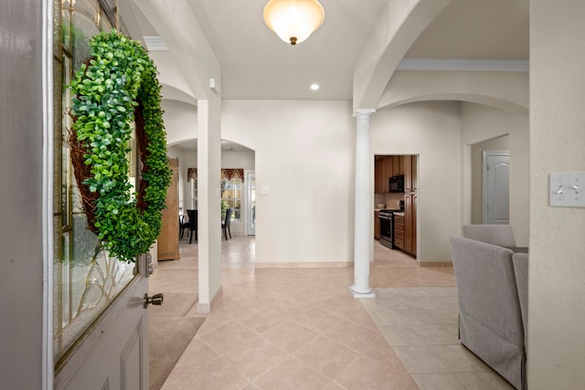 foyer entrance with light tile patterned floors and ornamental molding