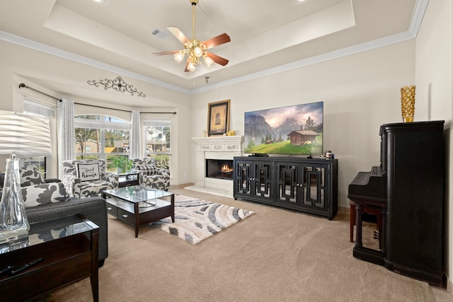 carpeted living room with ceiling fan, a raised ceiling, and crown molding