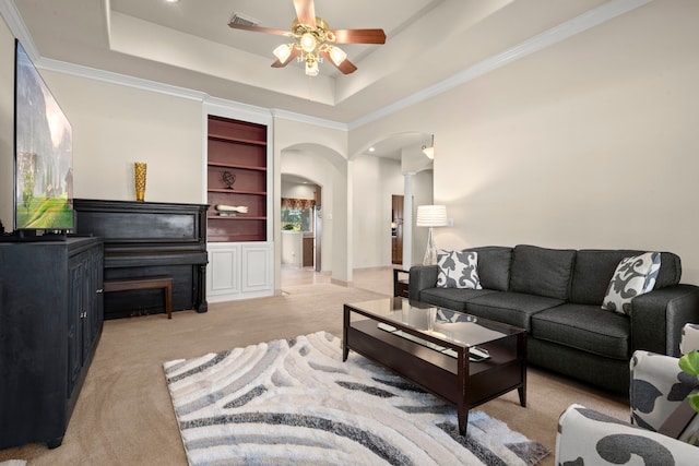 living room with light colored carpet, a raised ceiling, ceiling fan, and crown molding