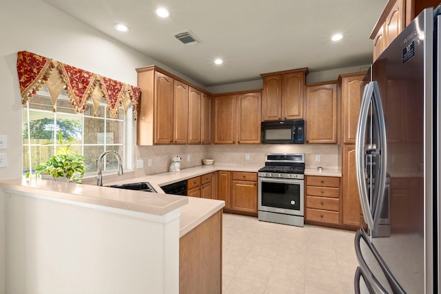 kitchen with backsplash, kitchen peninsula, sink, and stainless steel appliances