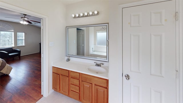 bathroom with hardwood / wood-style floors, ceiling fan, and vanity