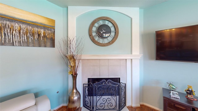 living room with wood-type flooring and a tile fireplace