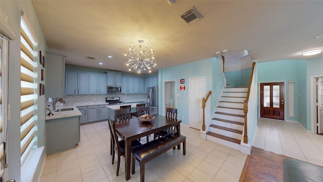 tiled dining space with an inviting chandelier and sink