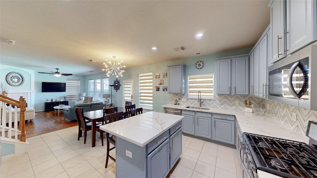 kitchen featuring light hardwood / wood-style floors, stainless steel appliances, sink, a center island, and gray cabinets