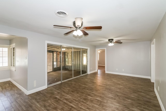 unfurnished room with ceiling fan and dark wood-type flooring