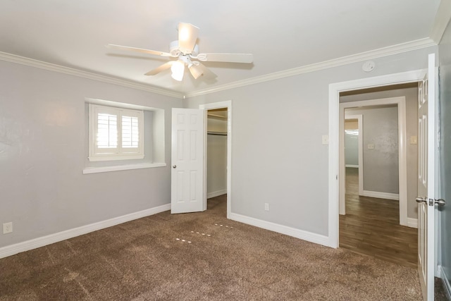 unfurnished bedroom with ceiling fan, a closet, dark carpet, and ornamental molding