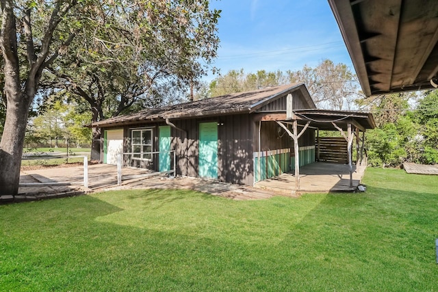 rear view of property with a lawn and an outdoor structure