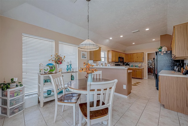 dining area featuring light tile patterned floors and a textured ceiling