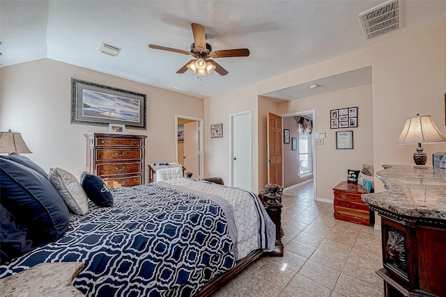 bedroom with ceiling fan, light tile patterned flooring, and a textured ceiling