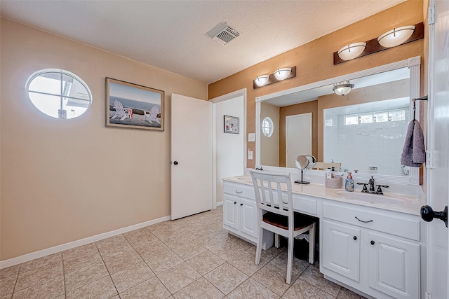 bathroom featuring tile patterned floors, vanity, and a textured ceiling