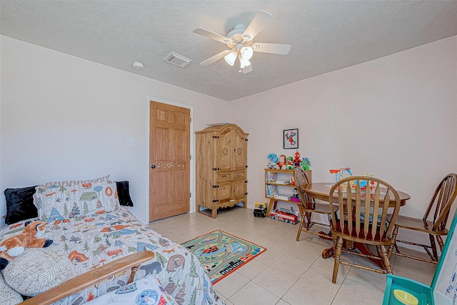 tiled bedroom featuring ceiling fan and a textured ceiling