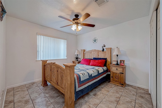 tiled bedroom featuring a textured ceiling, a closet, and ceiling fan