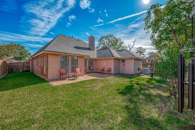 back of house featuring a lawn, a patio area, and central air condition unit