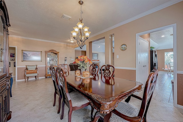 tiled dining room with a textured ceiling, an inviting chandelier, and crown molding