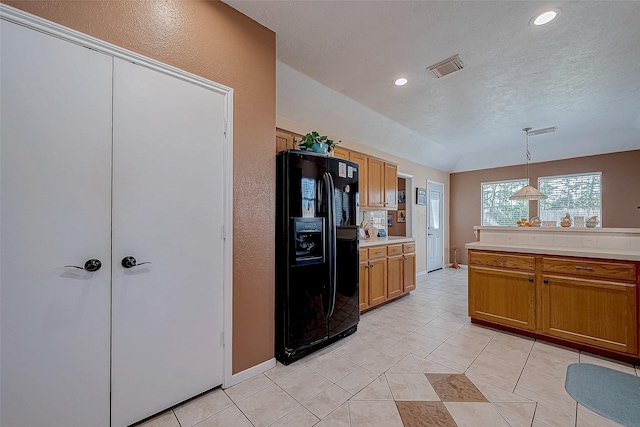 kitchen with black fridge with ice dispenser, a textured ceiling, light tile patterned floors, and pendant lighting